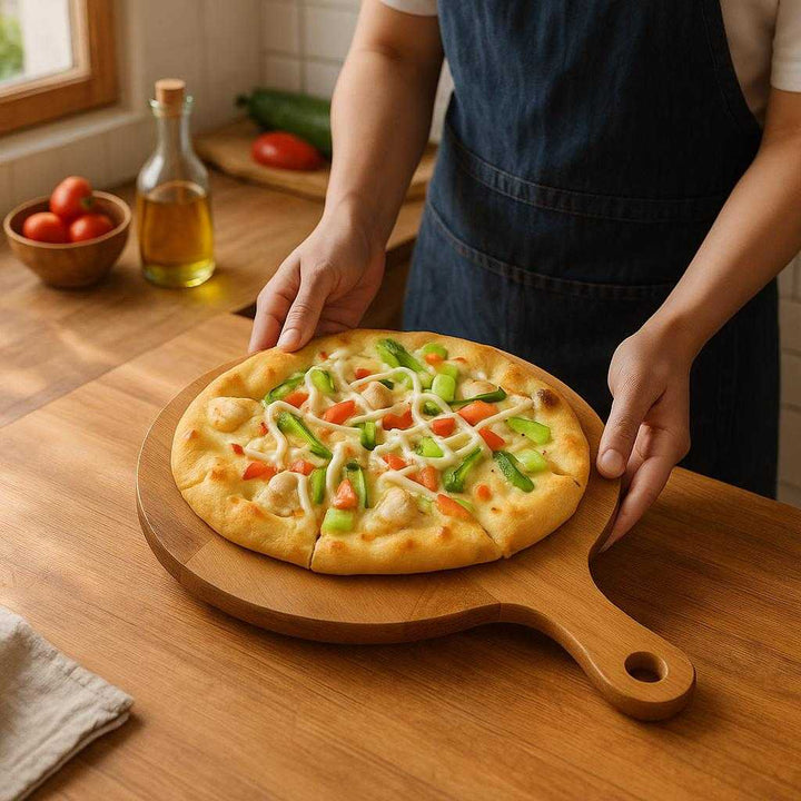 Acacia Pizzabakke - Træ, Massivt Træ, Glat Overflade, 1 stk, Holdbar og Let at Rengøre: A realistic cozy kitchen setting where the product is properly grounded on a wooden kitchen counter, being actively used by a chef preparing a homemade pizza, with natural lighting casting realistic shadows and showing clear contact points where the product touches the counter.