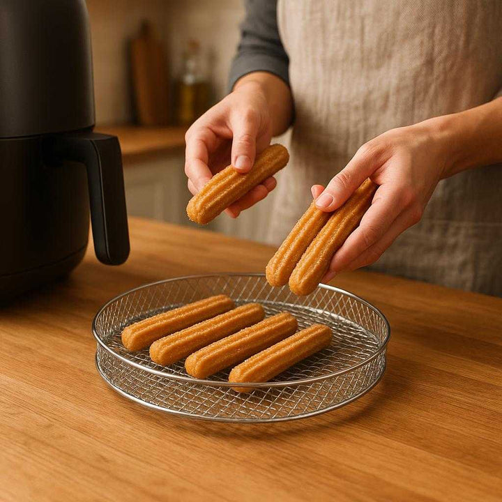 Airfryer Tilbehør Rist Tre - Høj Kvalitet til Sprød Madlavning og Optimal Luftcirkulation: A realistic kitchen setting where the airfryer accessory rack is properly grounded on a wooden kitchen counter, being actively used by a person placing churros onto the rack for cooking.