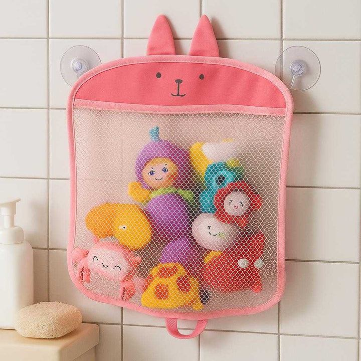 Badeværelses netpose til legetøj og tilbehør - Praktisk og rummelig opbevaring i lyserød, grå og blå: A realistic bathroom setting where the product is properly grounded on white tiled walls, being naturally placed with toys and accessories inside it, attached securely with suction cups, showing realistic shadows and contact points where the product meets the wall, illuminated by soft, natural lighting.
