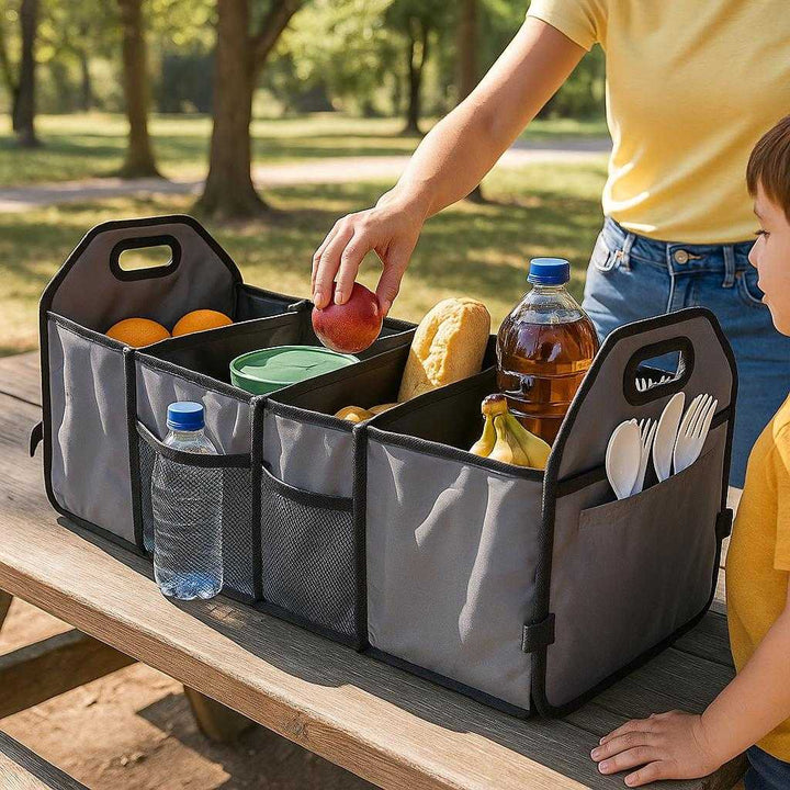 Bagagerumstaske Til Bilen i Gråt Design - Optimal Opbevaring og Organisering, Professionel Kvalitet: A different realistic setting at a picnic area where the bagagerumstaske is securely positioned on a picnic table, used to store and organize picnic essentials like food, drinks, and cutlery.