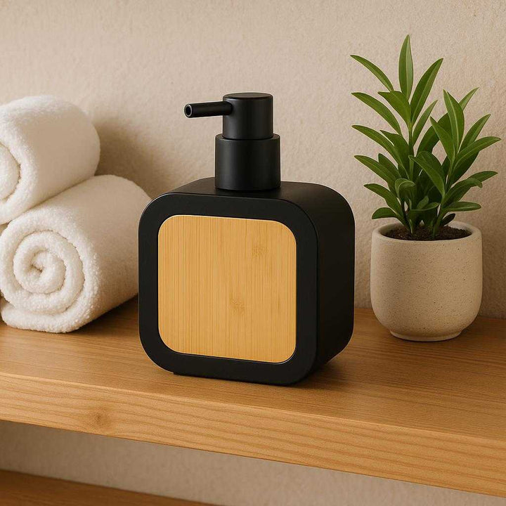 Bambus Sæbepumpe - Elegant og Funktionel Design til Badeværelset med Bambus Dekoration. The stylish soap dispenser is situated on a wooden bathroom shelf, surrounded by neatly rolled white towels and a small indoor plant, highlighting its natural bamboo accent in a spa-like atmosphere.