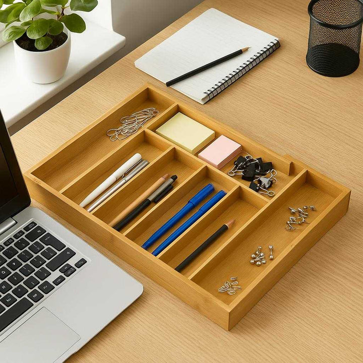 Bambus Skuffeorganisator: Justerbar og Udtrækkelig Indsats til Bestik og Småting: A different realistic office desk setting where the Bambus Skuffeorganisator is securely positioned on the desk, being used to organize small office supplies like pens, paper clips, and sticky notes.