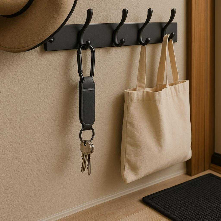 Barnevogn Krog - Praktisk og Holdbar Løsning til Forældre, Høj Kvalitet Babyudstyr: A different realistic home entryway where the product is securely positioned on a coat rack by the door, being used to hang a set of keys and a shopping bag.