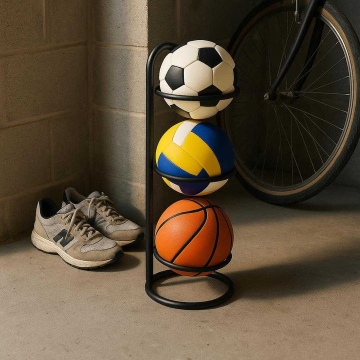 Boldholder til 3 Bolde i Sort Stål – Lodret Opbevaring til Væg og Gulv, Rygløs Design: A realistic garage setting where the product is properly grounded on a concrete floor, being naturally placed in a corner next to a pair of sneakers and a bicycle, with natural lighting coming from a window, casting realistic shadows and showing clear contact points where the product touches the floor.