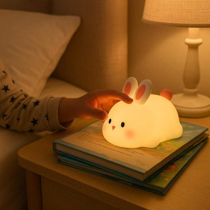 Børnelampe Kanin – Blød Silikone Natlampe med LED og Touch til Børneværelse: A realistic children's bedroom where the Børnelampe Kanin is properly grounded on a nightstand next to a bed.