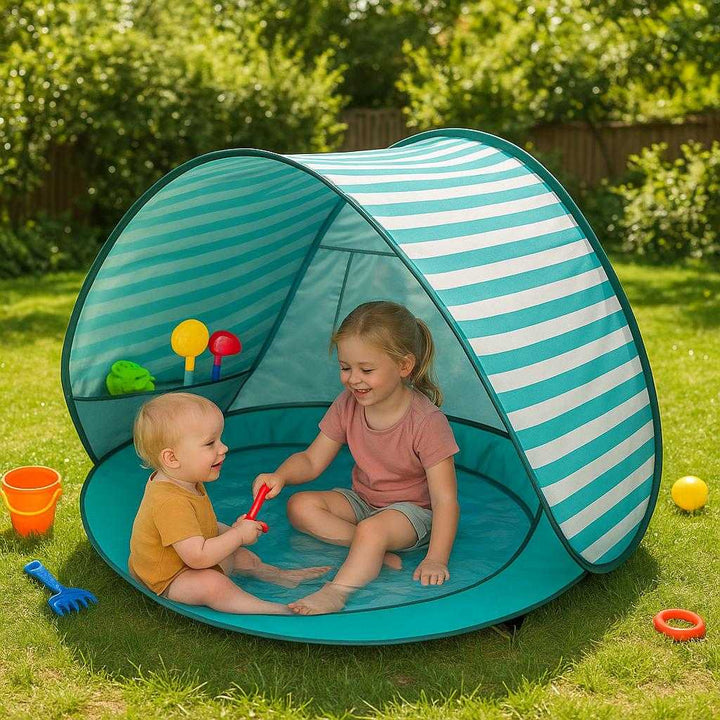 Børnestrandtelt: Moderne design i turkis og hvid, nem opsætning, solbeskyttelse og indbygget legeområde. In a sunny backyard, the 'Børnestrandtelt' is set up effortlessly as children enjoy a safe and playful afternoon under the UV-protected canopy, with colorful toys scattered around and lush greenery in the background.