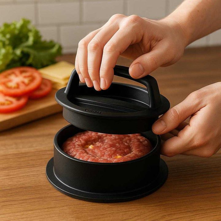 Burgerpresser - Sort, Holdbar Plastik til Perfekte Fyldte Burgerbøffer: A realistic kitchen setting where the burger press is properly grounded on a wooden countertop, being actively used by a pair of hands to press a stuffed burger patty, with natural lighting casting realistic shadows and showing clear contact points where the press touches the counter.