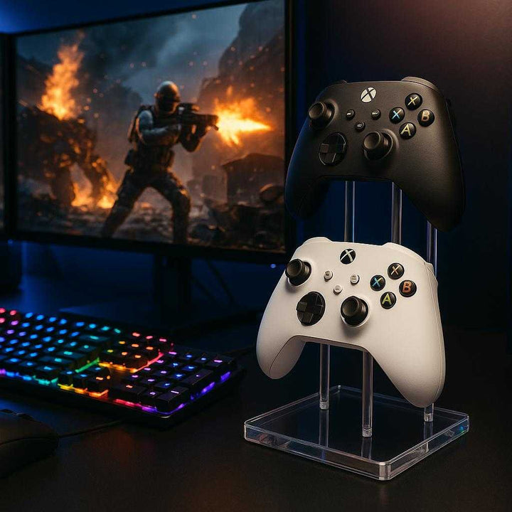 Controllerholder i Akryl til 2 Controllere - Elegant og Funktionel Gaming Opbevaring. The elegant acrylic controller holder, showcasing two gaming controllers, sits prominently beside a high-end gaming setup, with a glowing RGB keyboard and monitors displaying an intense gameplay scene.