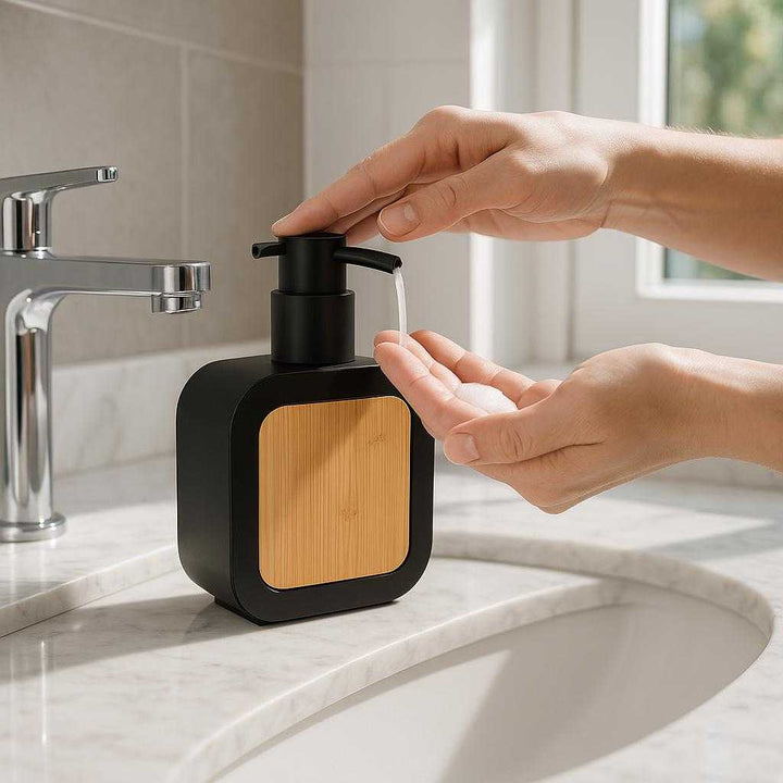 Design Sæbepumpe i Sort med Bambusdetaljer - Elegant Badeværelsesudstyr: A realistic modern bathroom setting where the black soap dispenser with bamboo details is properly grounded on a sleek, white marble countertop next to a silver faucet.