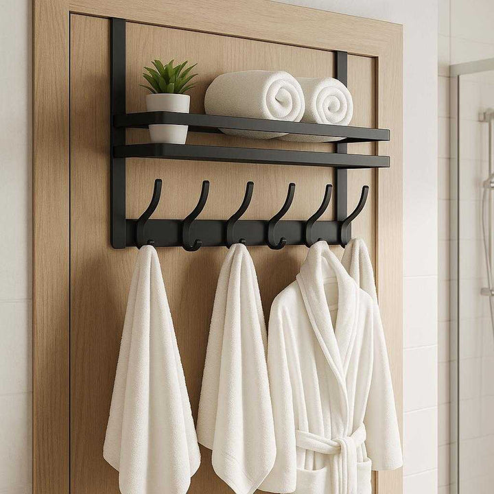 Dørehængt knagerække i metal – Pladsbesparende og multifunktionel opbevaringsløsning i grå: A different realistic bathroom setting where the product is securely positioned over a door, holding towels and a bathrobe, with toiletries like a small plant and rolled towels placed on the shelf.