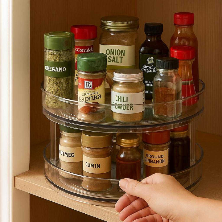 Drejefad i Klar Plast - Høj Kvalitet Lazy Susan til Køkkenopbevaring og Organisering: A realistic kitchen pantry setting where the Drejefad i Klar Plast is properly grounded on a wooden shelf, being actively used to organize a variety of spice jars and small bottles.