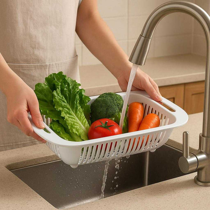 Dørslag i moderne design - Letvægt, holdbart og sammenklappeligt til nem opbevaring: A realistic kitchen setting where the colander is properly grounded on a kitchen counter, being actively used by hands to rinse fresh vegetables under running water.
