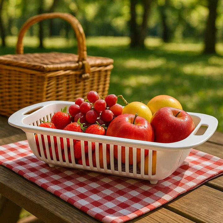 Dørslag i moderne design - Letvægt, holdbart og sammenklappeligt til nem opbevaring: A different realistic picnic setting where the colander is securely positioned on a picnic table, filled with freshly washed fruit.