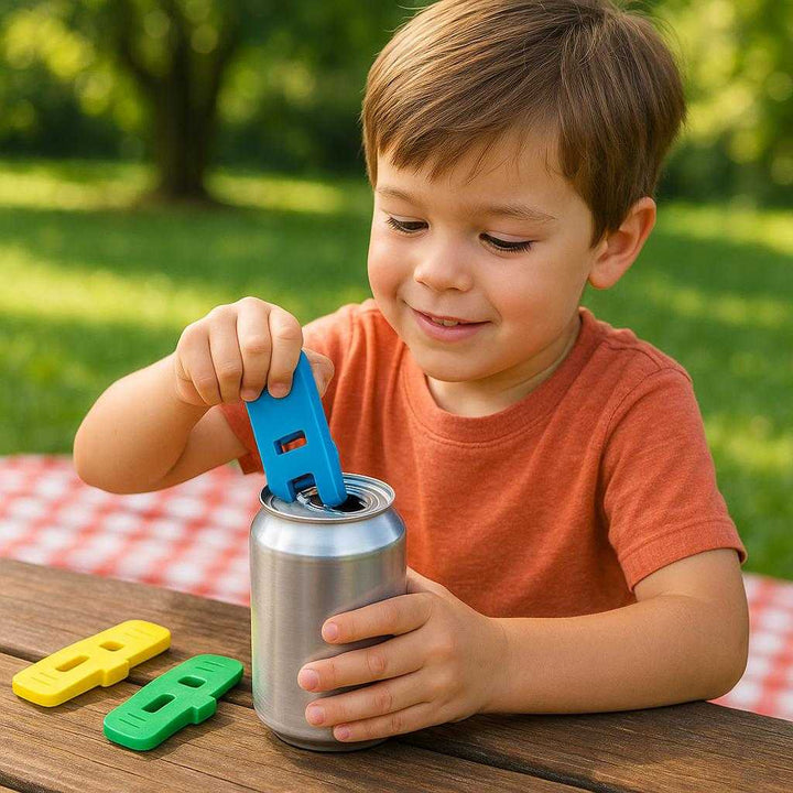 Dåseåbner i moderne design - ideel til ældre, nem at bruge, farvekodet for nem identifikation: A different realistic picnic setting where the can opener is securely positioned on a picnic table, being used differently by a young family member to open a canned beverage.