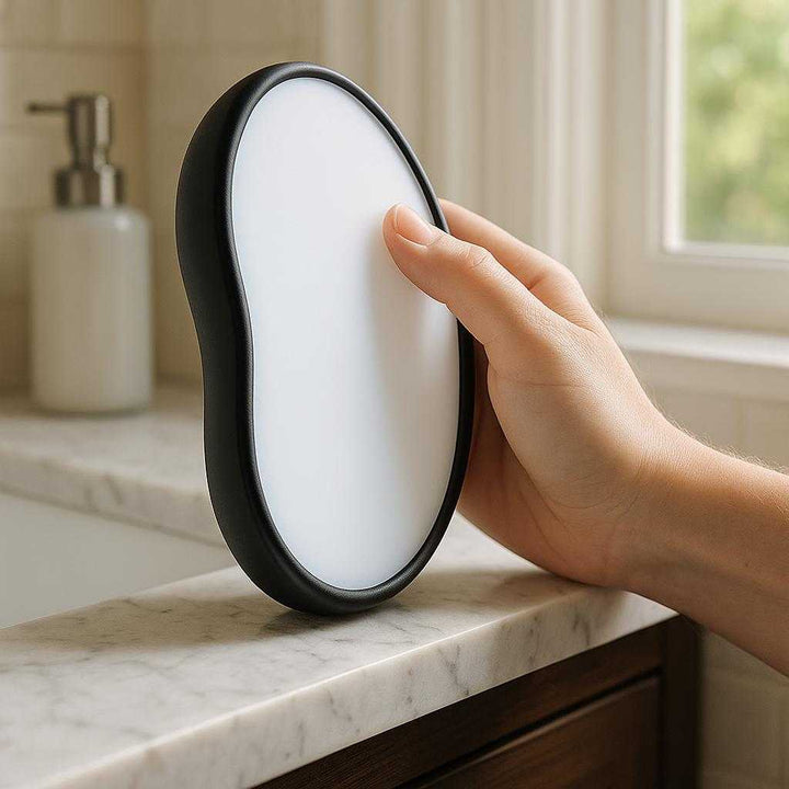 Effektiv Krystal Hårfjerner til Naturlig Hårfjerning - Professionel og Høj Kvalitet til Silkeblød Hud: A realistic bathroom setting where the product is properly grounded on the edge of a marble sink, being actively used by a person's hand.