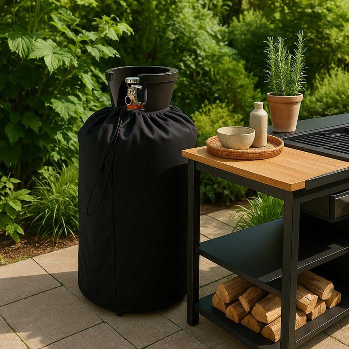 Gasflaskebetræk i Robust Plast med Tappehane - Praktisk og Elegant Beskyttelse til Din Gasflaske. In a lush garden setting, the elegantly covered gas bottle stands beside an outdoor kitchen setup, showcasing its stylish design while blending seamlessly with the greenery and modern decor.