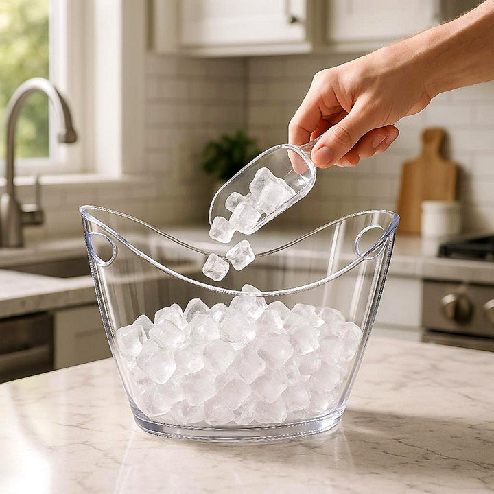 Gennemsigtig Ispand i Akryl med Håndtag til Moderne Hjem, Minimalistisk Design: A realistic modern kitchen setting where the acrylic ice bucket is properly grounded on a sleek marble countertop, being actively filled with ice cubes by a hand.
