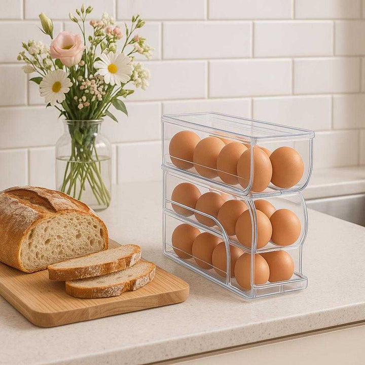 Æggeholder – Gennemsigtig og Pladsbesparende Opbevaring til Køleskabet i Høj Kvalitet. A modern kitchen countertop with the sleek egg holder placed stylishly alongside artisanal bread and a vase of fresh flowers, highlighting its space-saving design.