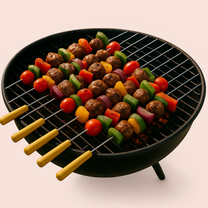 Enhanced Grillspyd i Rustfrit Stål med Træhåndtag – Høj Kvalitet til Perfekt Grillmad. A group of Grillspyd i Rustfrit Stål med Træhåndtag skewers are loaded with colorful vegetables and meats, sizzling over an open charcoal grill during a sunny outdoor barbecue.