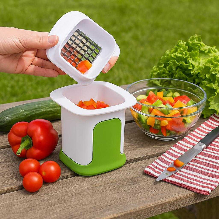 Grøntsagshakker med Opsamler i Hvidt og Grønt Design – Kompakt og Effektiv til Madlavning: A different realistic picnic setting where the product is securely positioned on a picnic table, being used to chop bell peppers for a fresh salad.