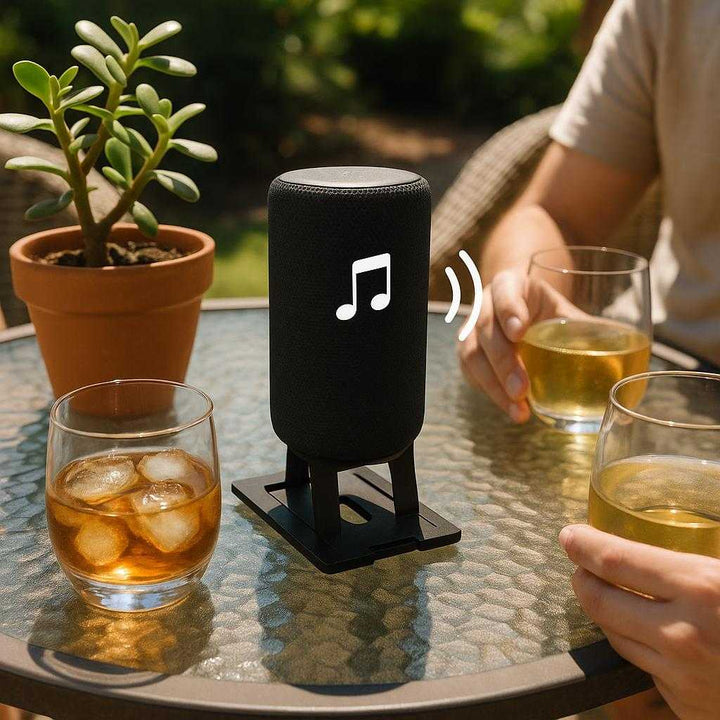 Højttalerstøtte i moderne design - Optimal lyd og stabilitet i sort og hvid: A different realistic outdoor patio setup where the speaker stand is securely positioned on a circular glass table.