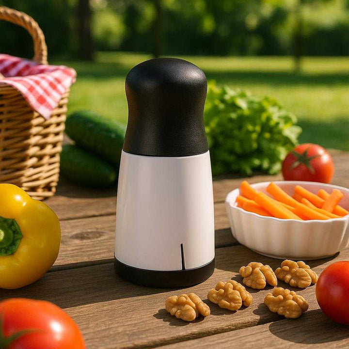 Hånddrevet 3-i-1 Rivejern - Perfekt til Ost, Grøntsager og Nødder i Moderne Sort og Hvid Design: A different realistic outdoor picnic setting where the Hand-Cranked 3-in-1 Grater is securely positioned on a picnic table, surrounded by fresh vegetables and nuts ready to be grated.