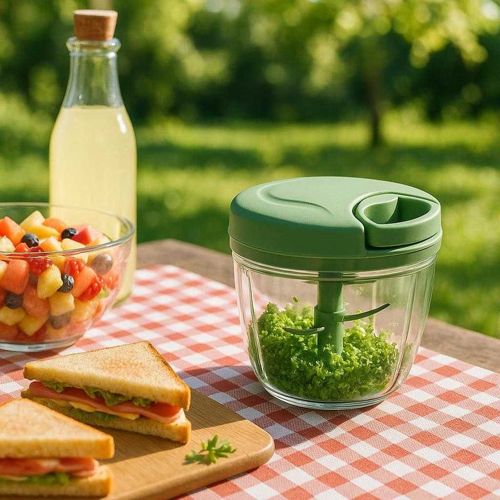 Håndhakker i moderne design - tilgængelig i blå, grøn og lyserød: An outdoor picnic scene, set in a lush garden on a sunny afternoon.