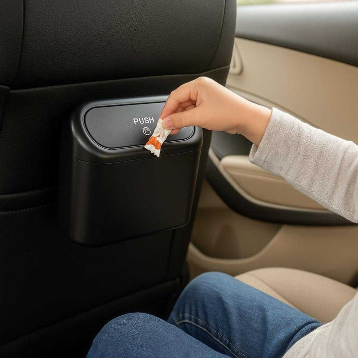 Hængende bilskraldespand i sort – Kompakt, let og fleksibel affaldsløsning til alle biltyper: A different realistic setting in the backseat of a car, where the product is securely positioned on the back of the passenger seat, being used by a child who is casually dropping a candy wrapper into it, with proper physics, shadows, and realistic integration into the family-friendly environment.