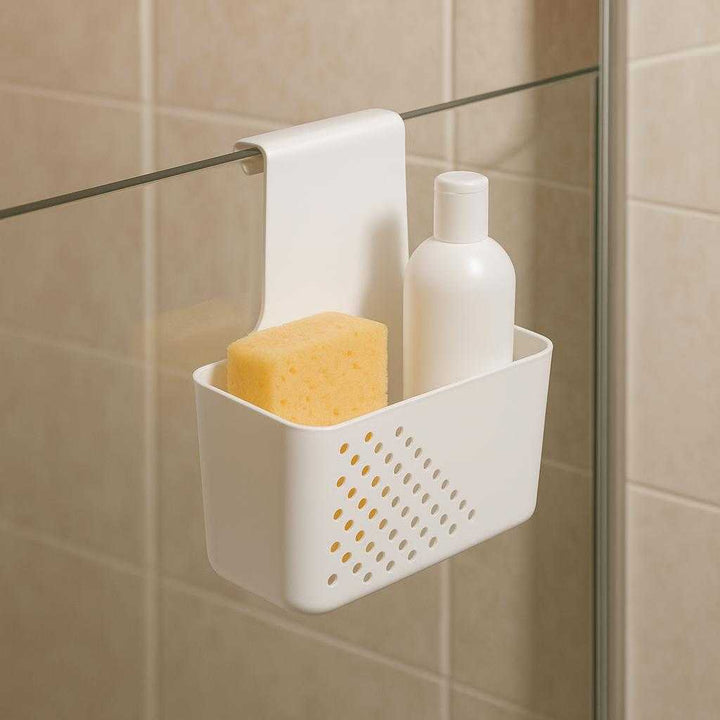 Hængende skabsorganisator – Multifunktionel opbevaring til køkken og bad i moderne hvid plast: A different realistic bathroom setting where the product is securely positioned over the edge of a shower cubicle partition, naturally holding shower essentials like a sponge and shampoo bottle.