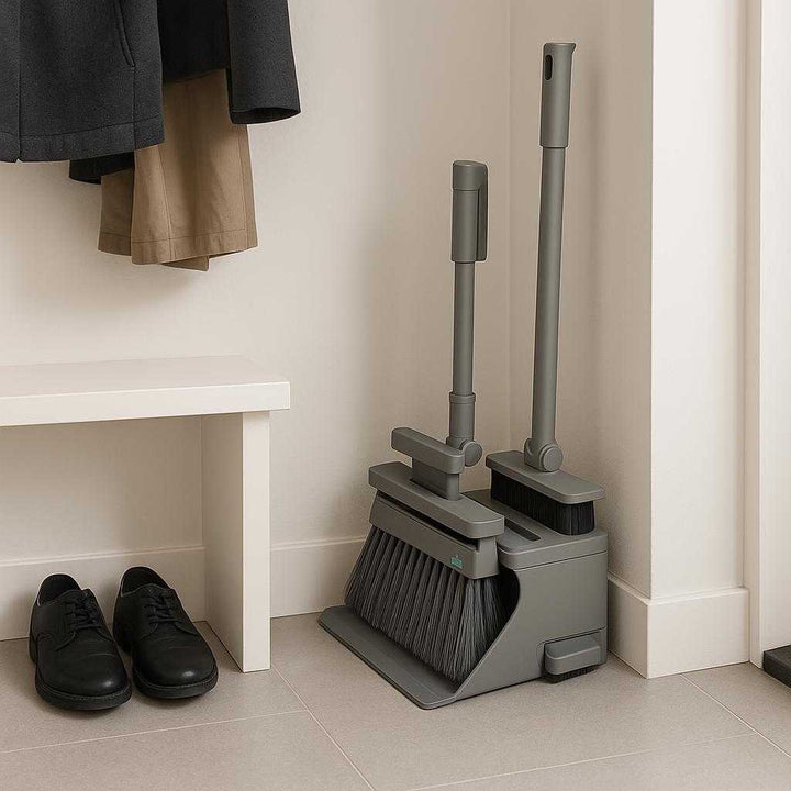 Integreret Fejesæt med Kost, Skraber og Opbevaring i Grå og Hvid - Effektiv Rengøring med Stil. The stylish gray and white cleaning set is neatly stored in a corner of a minimalist mudroom, emphasizing organization and efficiency with shoes and jackets neatly lined up nearby.