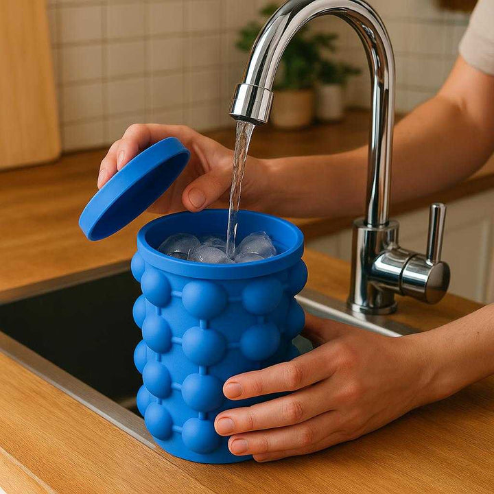 Isspand i silikone - Kompakt og fleksibel isopbevaring med låg i moderne design: A realistic kitchen setting where the product is properly grounded on a wooden kitchen counter, being actively used by a person filling it with fresh water from a chrome faucet.