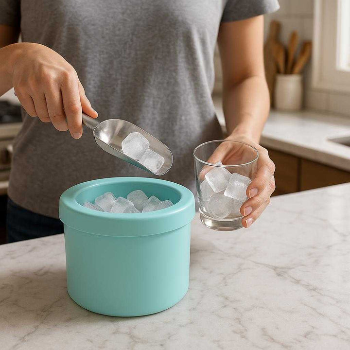 Isterningebøtte i Silikone – Praktisk og Kompakt Opbevaring i Blå, Grå og Gul: A realistic kitchen setting where the product is properly grounded on a marble countertop, being actively used by a person preparing beverages.