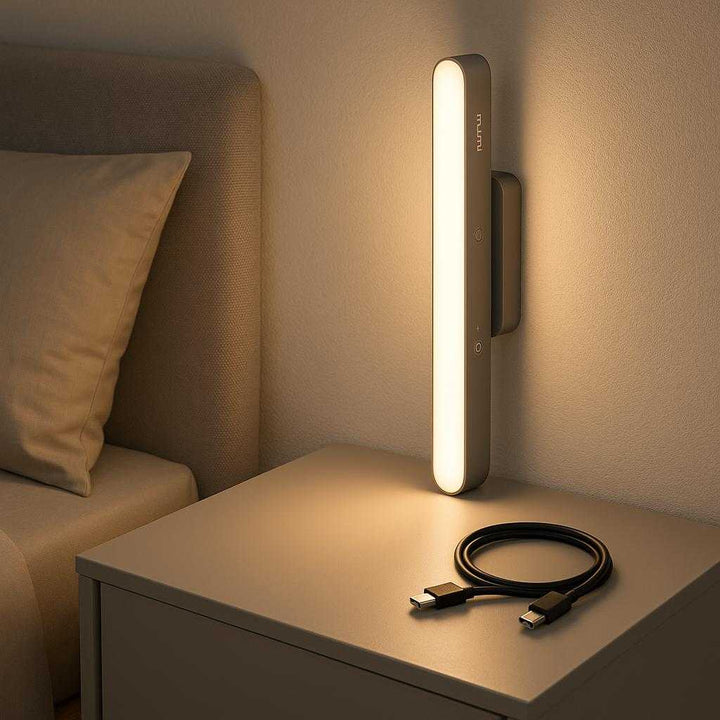 Justerbart LED natlys med berøringsfølsom kontrolpanel - Grå og sort. Placed stylishly on a modern bedside table, the LED nightlight casts a gentle glow in a minimalist bedroom, highlighting its contemporary design and ease of use.