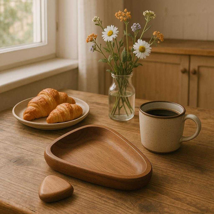 Kaffebakke i valnøddetræ - Moderne og funktionel med naturligt design. A cozy Scandinavian-style kitchen, where the walnut wood tray is elegantly placed on a rustic wooden table, surrounded by freshly brewed coffee, pastries, and a vase with seasonal wildflowers. Soft morning light streams through a nearby window, casting gentle shadows to emphasize the tray's natural grain and modern design, enhancing the warm and inviting atmosphere.
