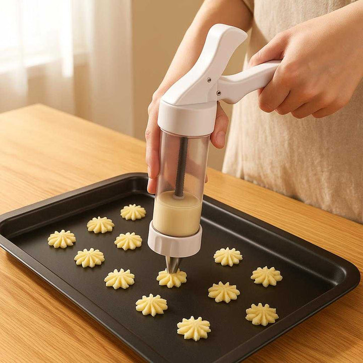 Kageformspistol i moderne design - nem at bruge, skaber forskellige former, giver ensartede resultater: A realistic kitchen setting where the kageformspistol is properly grounded on a wooden countertop, being actively used by a person to create beautiful star-shaped cookies.
