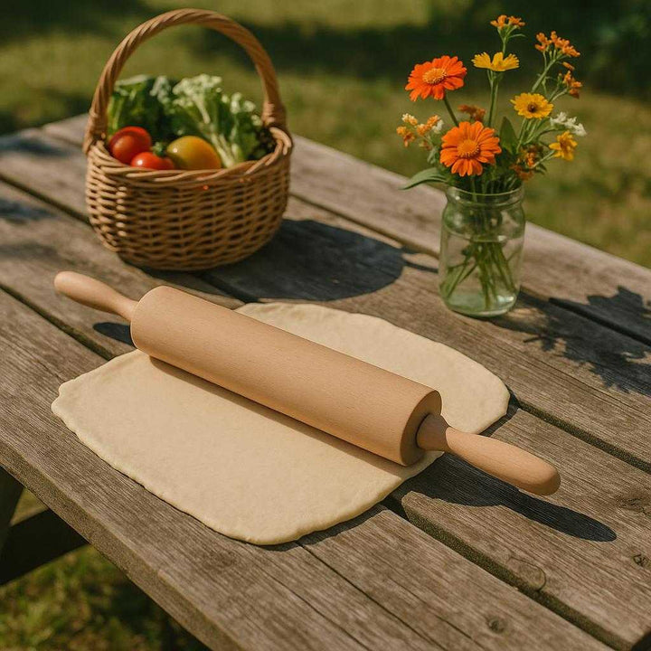 Kagerulle i Bøgetræ - Klassisk og Holdbar med Ergonomiske Håndtag: A different realistic outdoor picnic setting where the Kagerulle i Bøgetræ is securely positioned on a rustic picnic table, naturally placed beside a partially rolled-out pastry sheet.