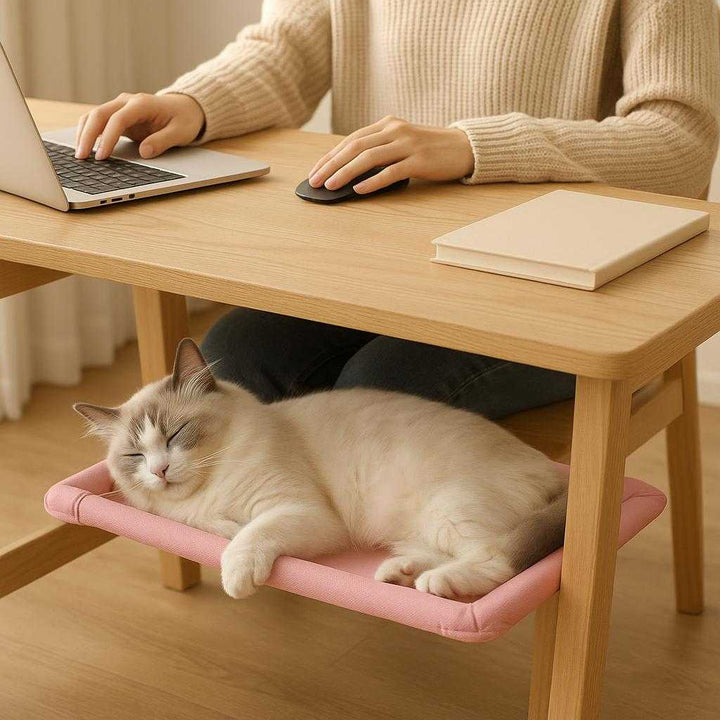 Kattehængekøje i Moderne Design - Nem Installation, Pladsbesparende, Komfortabel - Tilgængelig i Lyserød, Blå, Beige, Sort: A different realistic home office environment where the cat hammock is used below a desk, secured between the desk legs fitting snugly.