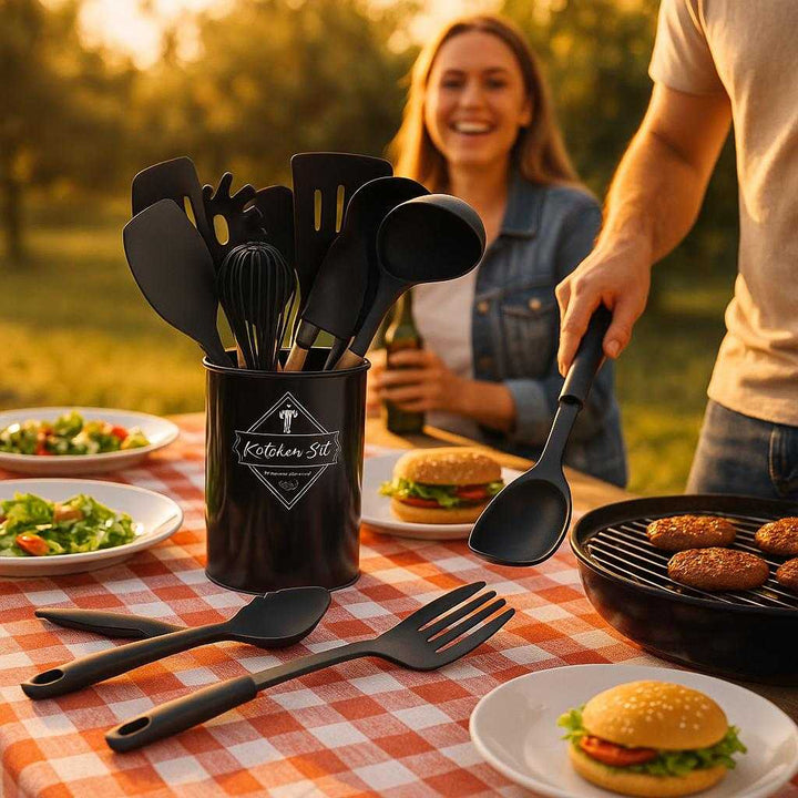 Køkkensæt med 12 Dele i Høj Kvalitet - Professionelt Køkkenredskabssæt med Træhåndtag og Sorte Silikonehoveder: A different realistic outdoor barbecue setting where the product is securely positioned on a picnic table, being used naturally in a family gathering.