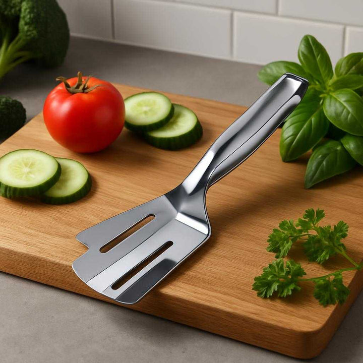 Køkkentang i Rustfrit Stål - Professionelt Design og Høj Kvalitet til Hjemmekokke. In a modern kitchen, the polished stainless steel tongs rest stylishly on a wooden cutting board beside fresh vegetables and herbs, ready for elegant meal preparation.