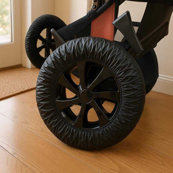 Klapvogns Hjul Covers i Sort Plastik og Tekstil - Beskytter og Forlænger Hjullevering, Let at Rengøre, Lille og Stor Pakkepost: A different realistic indoor home setting where the stroller is securely positioned on a wooden floor.