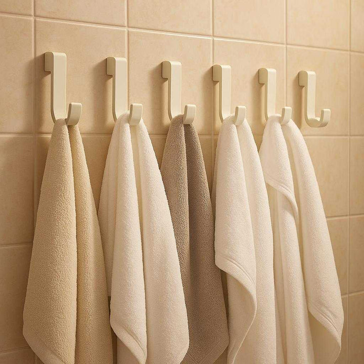 Knagerække i Hvid Mat Metal - Selvklæbende og Pladsbesparende til Hjemmet: A different realistic bathroom setting where the product is securely positioned on tiled walls, each hook being used to hold towels and bathrobes, naturally integrating with the bathroom decor.