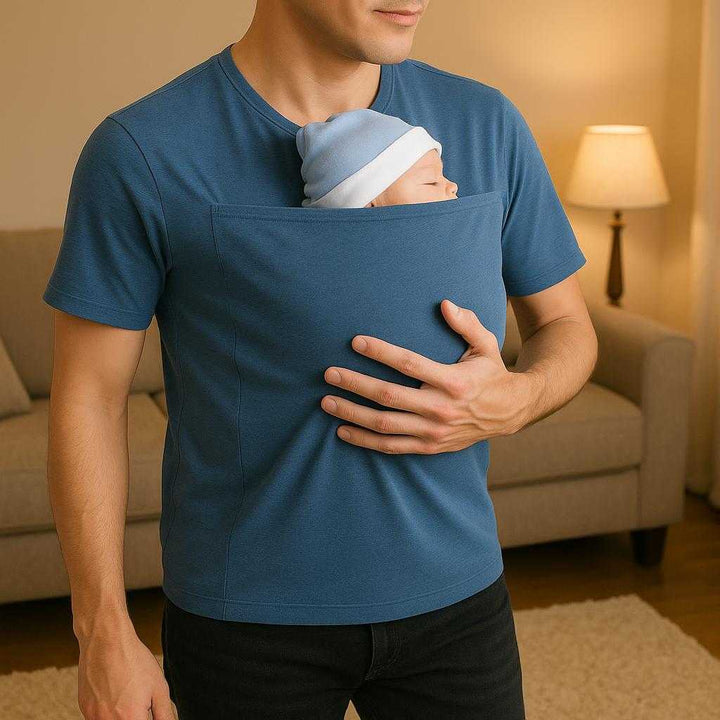 Kænguru Far T-shirt i Bomuld og Elastan - Armygrøn, Grå, Gråblå, Sort - Håndfri Bæring og Sikkerhed: A different realistic home setting where the product is securely positioned on a standing parent in a cozy living room.