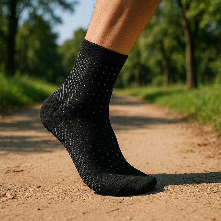 Kompressionsstrømper til Løb - Sort, Hvid - Forbedrer Blodcirkulation: A realistic outdoor jogging trail where the compression sock is properly grounded on a runner's foot, actively being used while running.