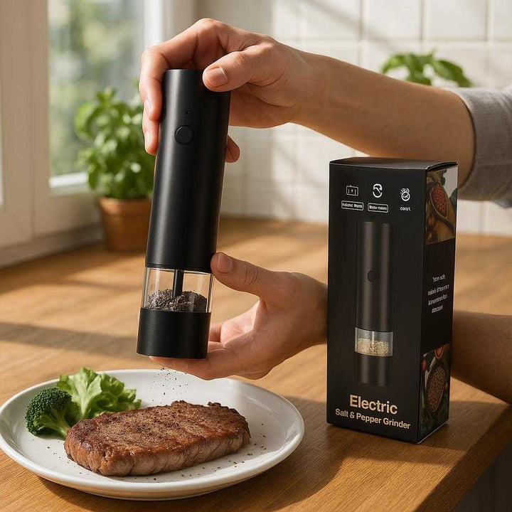 Krydderikværn - Elektrisk og Automatisk med LED-lys og Justerbar Grovhed, Bedst i Test: A realistic kitchen setting where the electric spice grinder is properly grounded on a wooden kitchen counter, being actively used by a pair of hands to grind pepper onto a freshly cooked steak on a plate.