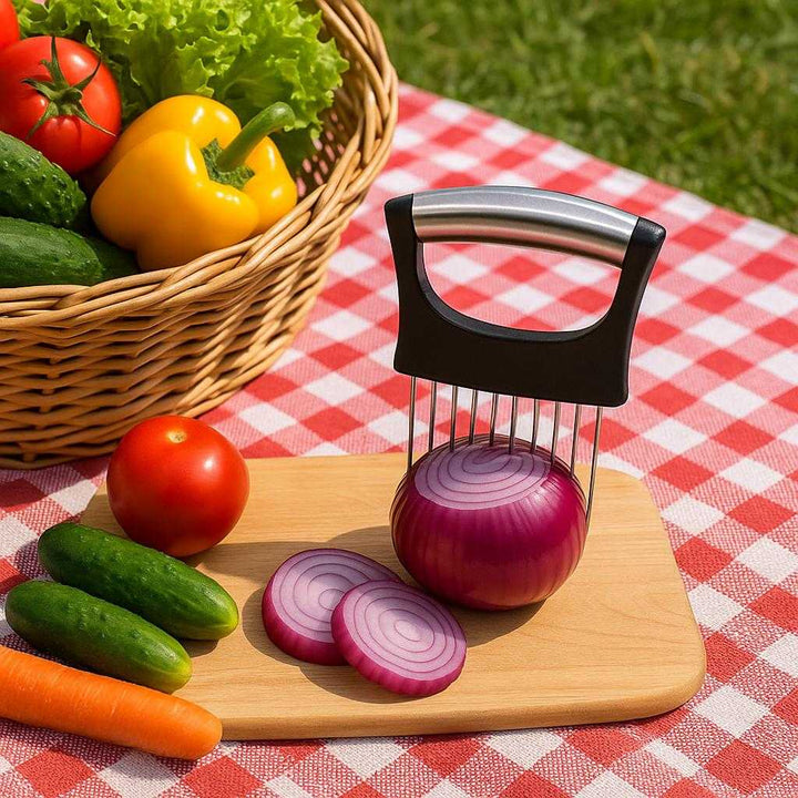 Løgskærer med Præcisionsholder - Rustfrit Stål, Sikker Skæring og Beskyttelsesgreb: A different realistic outdoor picnic setting where the product is securely positioned on a checkered picnic blanket, being placed alongside various vegetables ready for slicing.