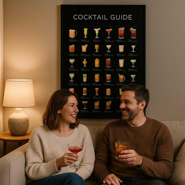 Lærredsbillede Cocktail Guide – Professionel Vægdekoration i Høj Kvalitet til Bar & Hjem. In a stylish living room, the cocktail guide adorns the wall above a plush sofa, with a couple enjoying a pair of cocktails, adding a sophisticated touch to a cozy night in.