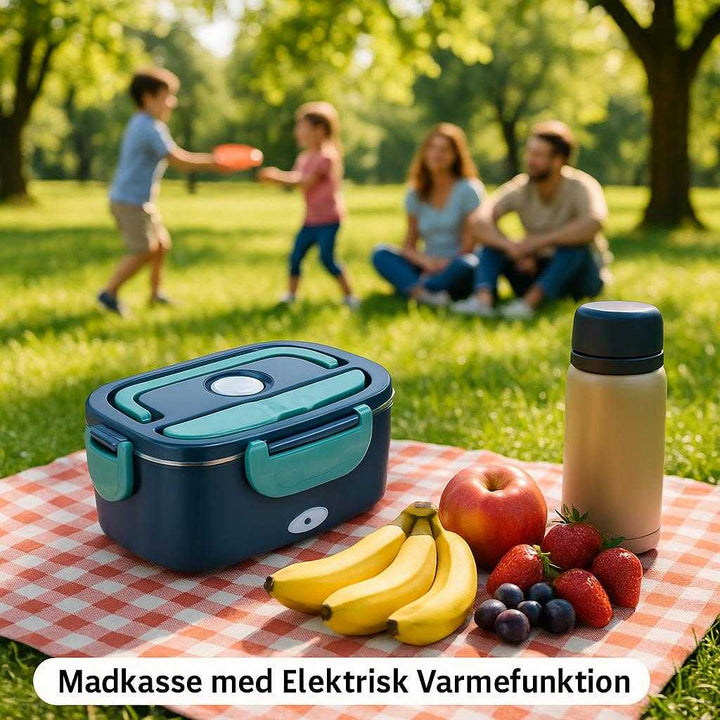 Madkasse med Elektrisk Varmefunktion - Praktisk og Moderne Design i Mørkeblå og Turkis. An outdoor picnic scene in a lush green park, where the 'Madkasse med Elektrisk Varmefunktion' is nestled on a gingham blanket beside assorted fresh fruits and a thermos filled with a hot drink. A young family relaxes nearby, children playing with a frisbee, as the vibrant colors of the madkasse stand out amidst the natural setting. Dappled sunlight from the overhanging trees creates a lively and carefree atmosphere.