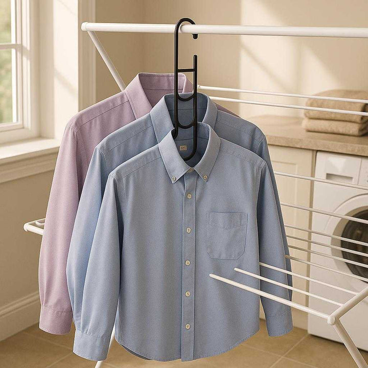 Magisk bøjle i sort - metal, plastik, gummi - Pladsbesparende og organiseret: A different realistic laundry room setting where the magic hanger in black is securely positioned over a drying rack, being used to air dry shirts in an organized manner.