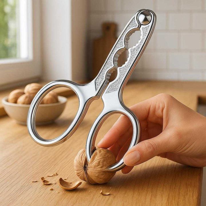 Nødde knækker i sølvfarvet rustfrit stål - Let at bruge, holdbar og ergonomisk: A realistic kitchen setting where the product is properly grounded on a wooden countertop, being actively used by a person to crack a walnut.
