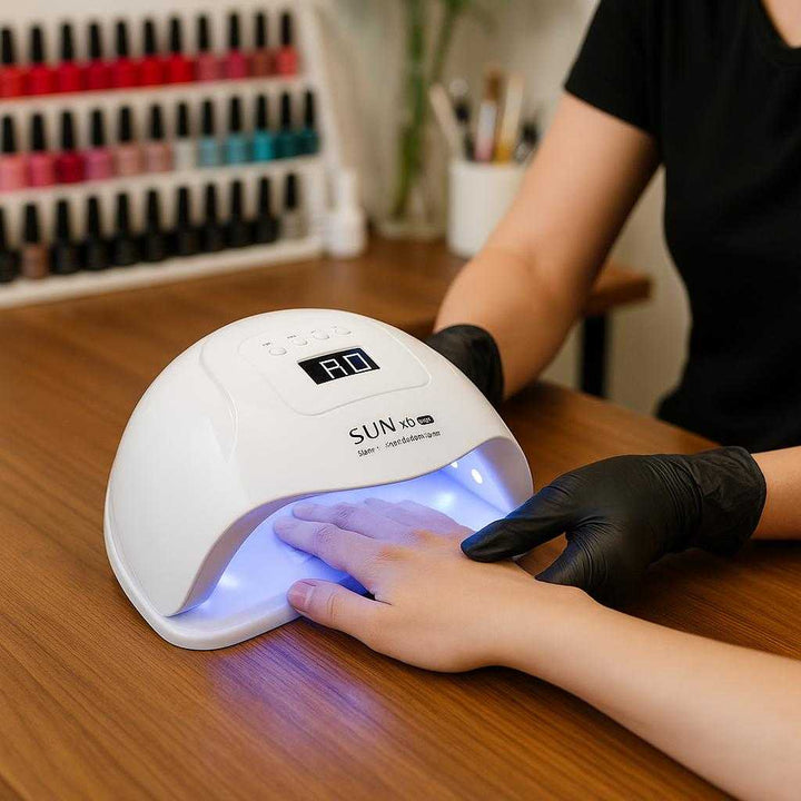 Negletørrer - Professionel og Effektiv UV/LED Tørring i Høj Kvalitet til Perfekte Resultater: A different realistic professional nail studio setting where the nail dryer is securely positioned on a polished wooden table, being used by a professional nail technician as they guide a client's hand under the lamp, with proper physics, shadows, and realistic integration into the vibrant, well-lit studio environment filled with nail polish bottles and tools.
